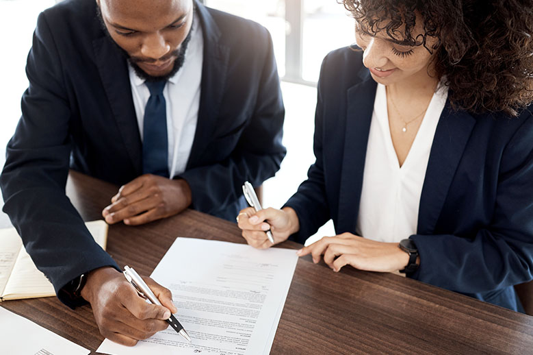A pair of professionals reviewing banking documents.