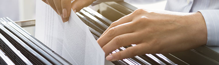 Office clerk searching files in the filing cabinet