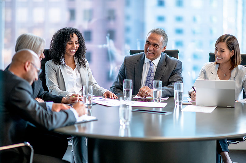 A group of business people sit around a round table