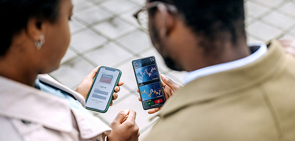 A couple is reviewing their digital investment portfolio on their cell phone.