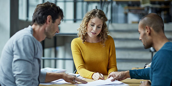 A group of colleagues at a non-profit organization review asset documents.