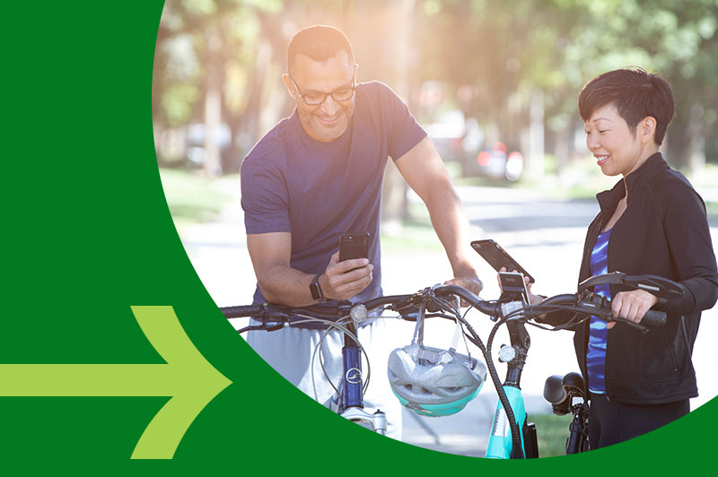 Friends using phones to transfer money while biking together