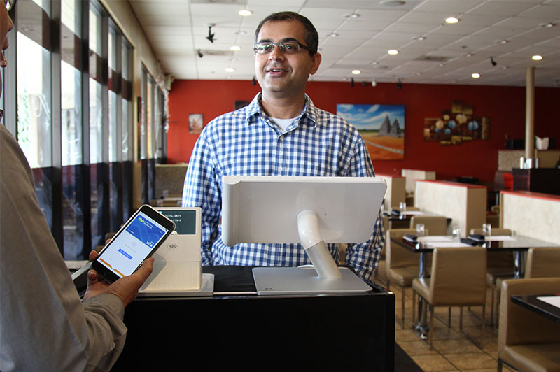 Waiter taking payment with Clover kiosk