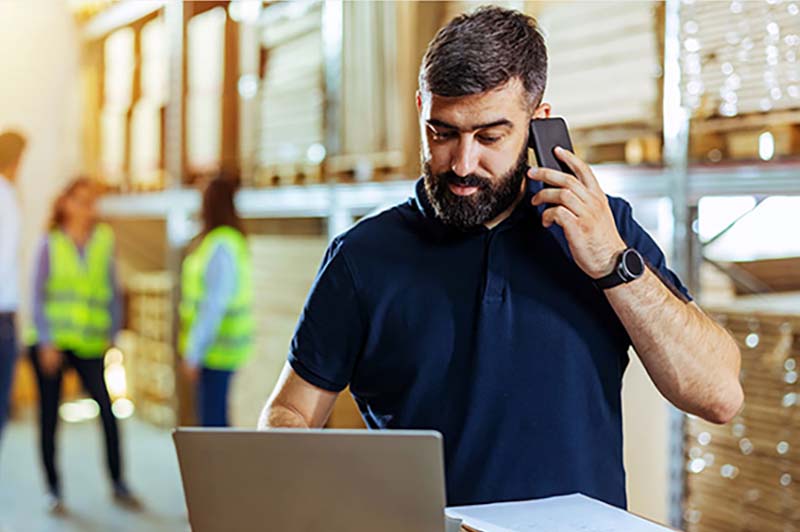 A man in a warehouse takes a phone call