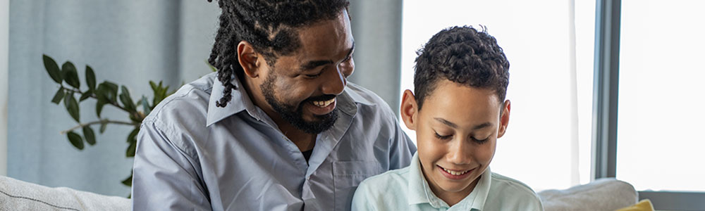 Father and son at home using laptop