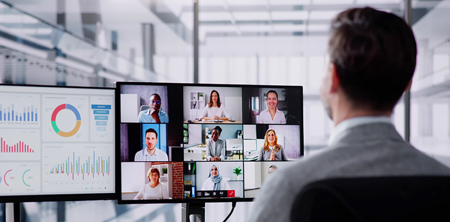 A businessman attends a virtual meeting with 9 other people on camera